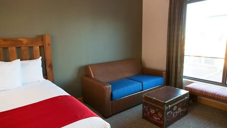 The bed and sofa in the accessible Family Suite (Accessible bathtub)